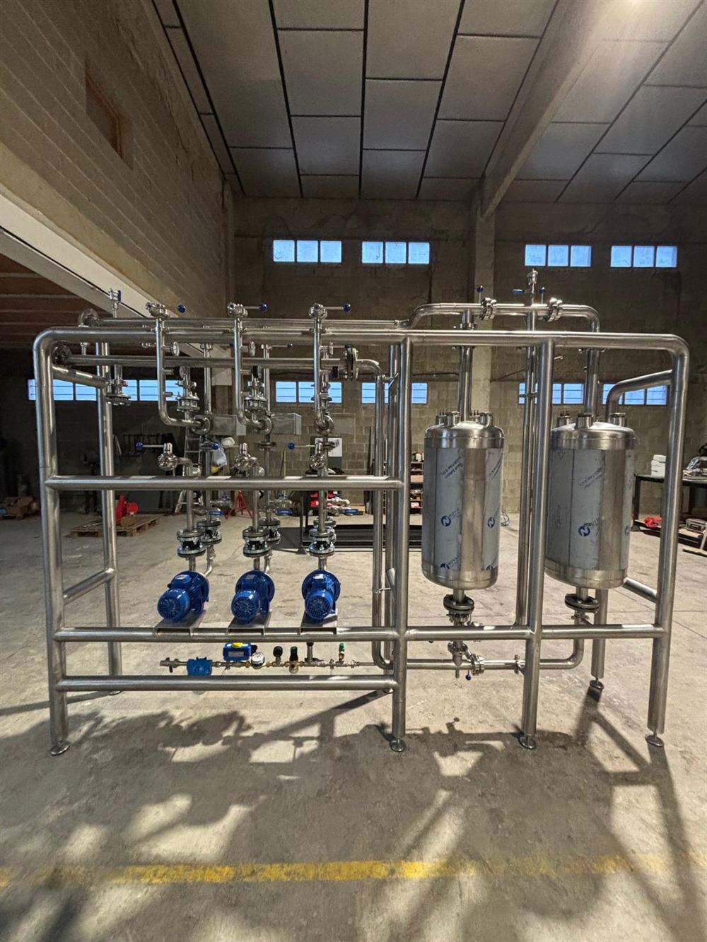 Skid industrial de acero inoxidable con bombas, válvulas y tuberías