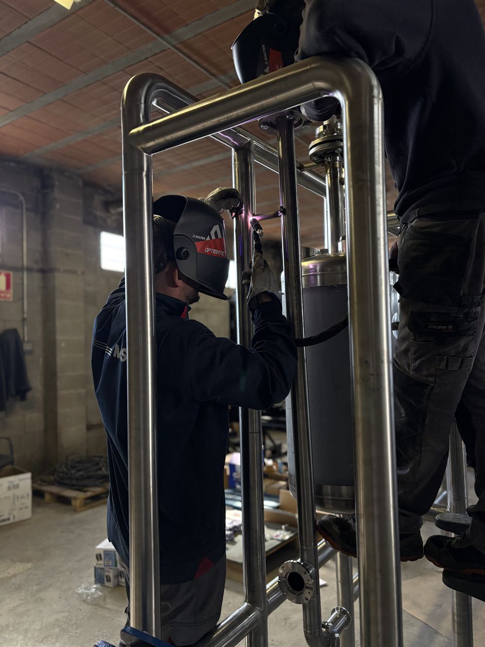 Operarios montando un skid tubular de acero inoxidable para industria farmacéutica